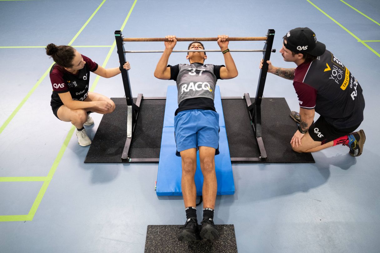Talent team watching a young male athlete testing his strength during an incline pull up test at a YouFor2032 Testing day event.