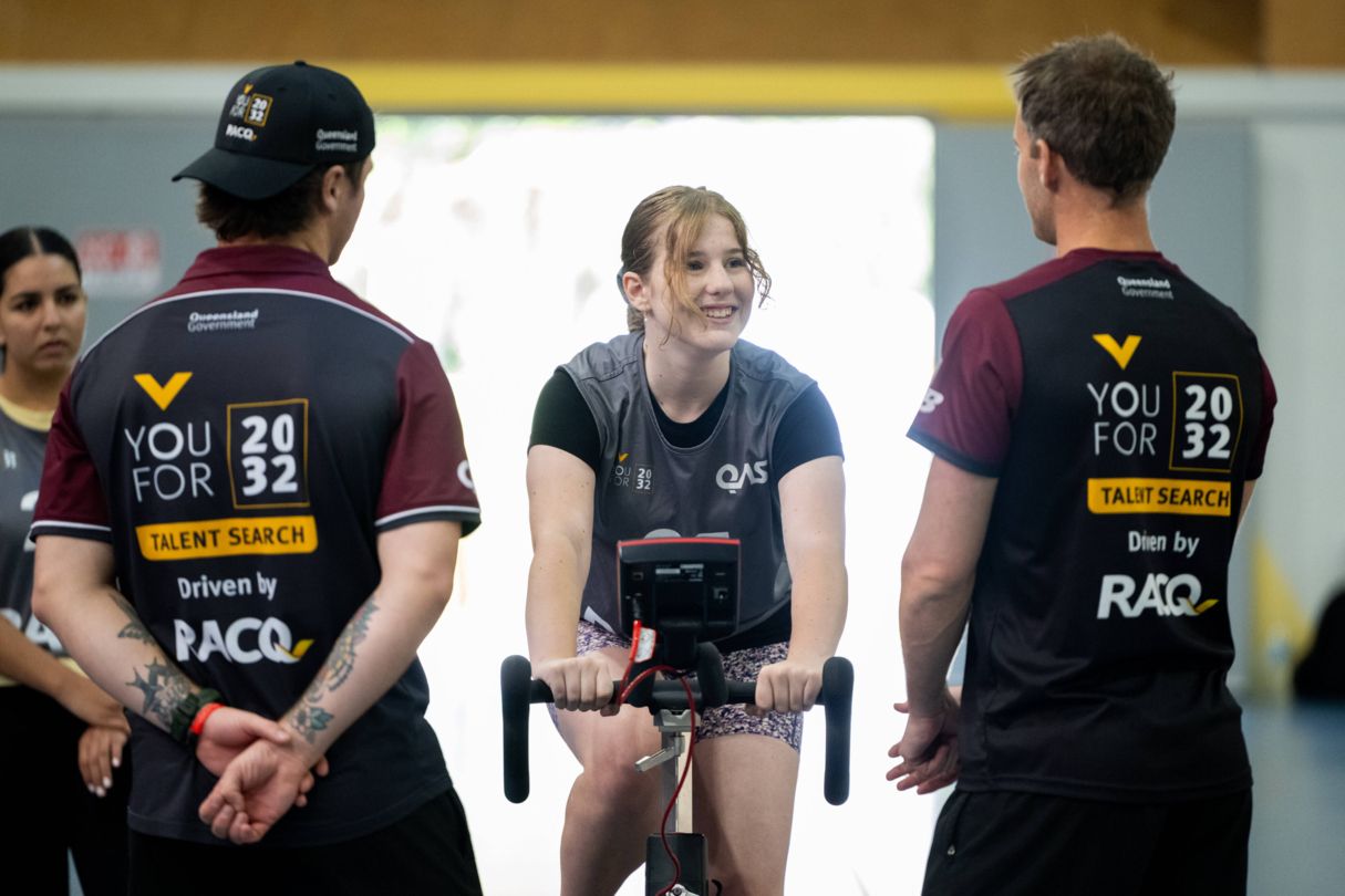 Talent team watching female athlete on a exercise bike during a testing exercise.