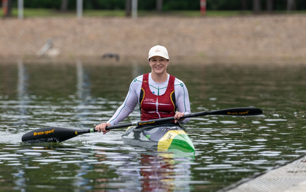 Susan Seipel sits in a kayak in the water, smiling at the camera – credit JGR Images