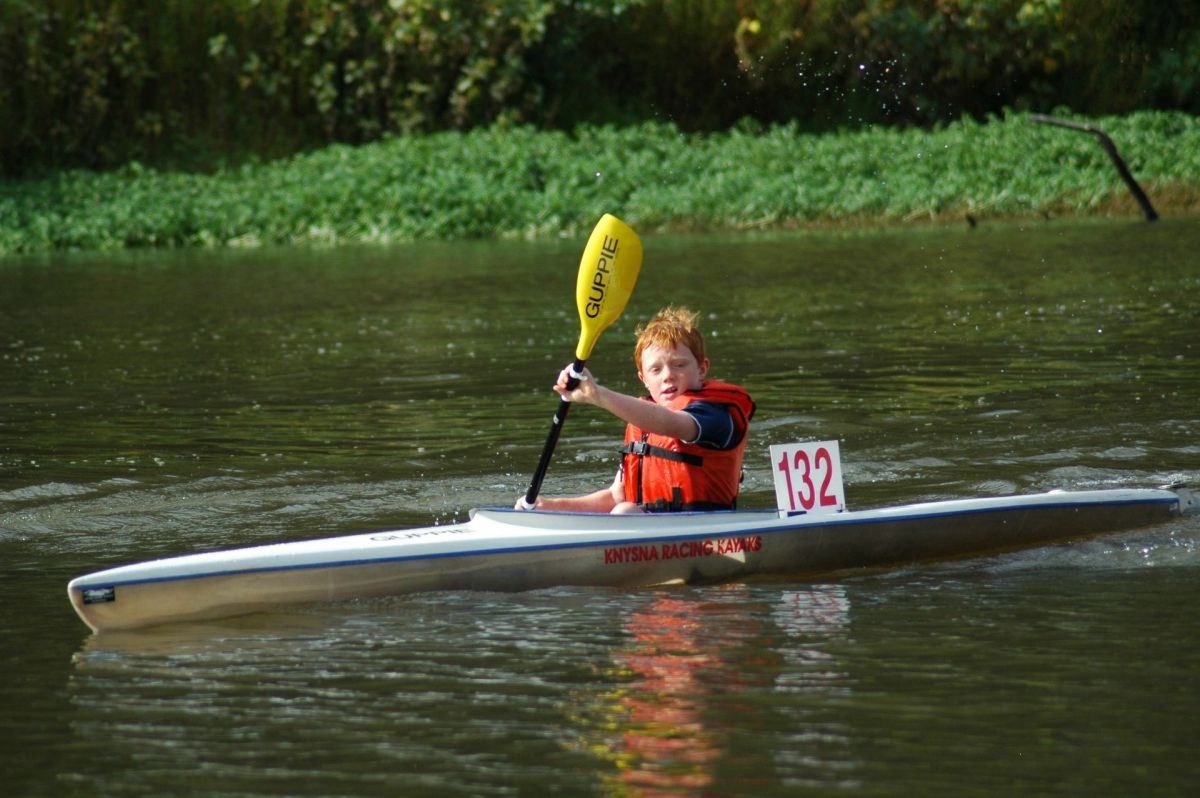 A young Jean van der Westhuyzen is kayaking on the water