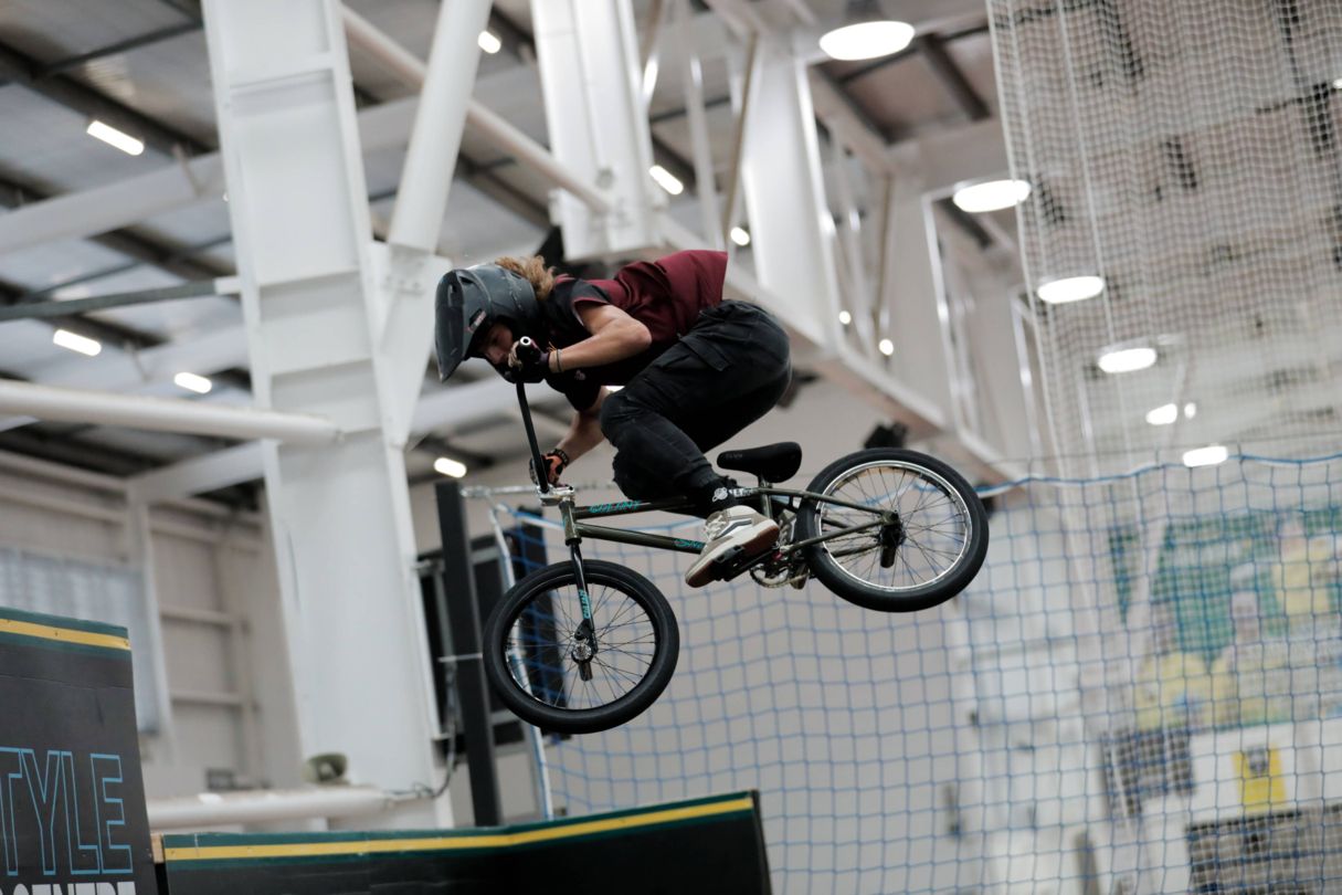 Young athlete on BMX bike jumps in air.