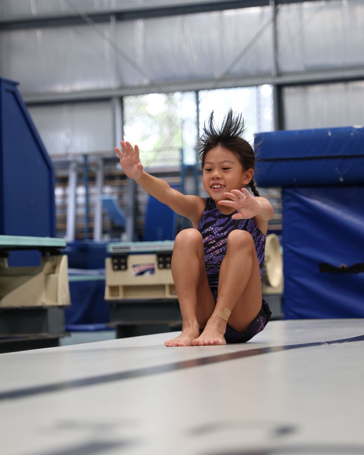 Young girl smiling on gymnastics mat