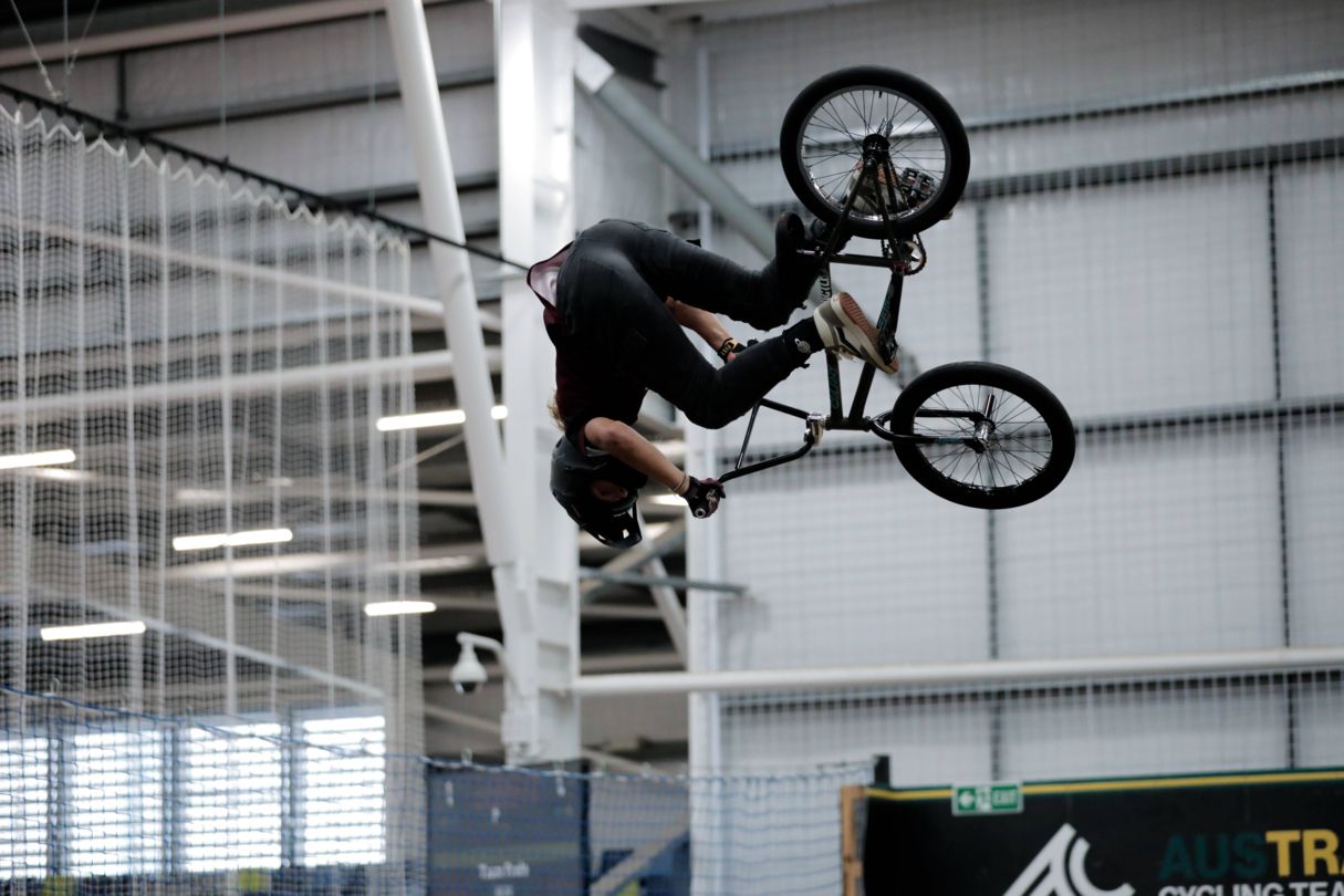 Athlete on a BMX bike doing a flip in the air.