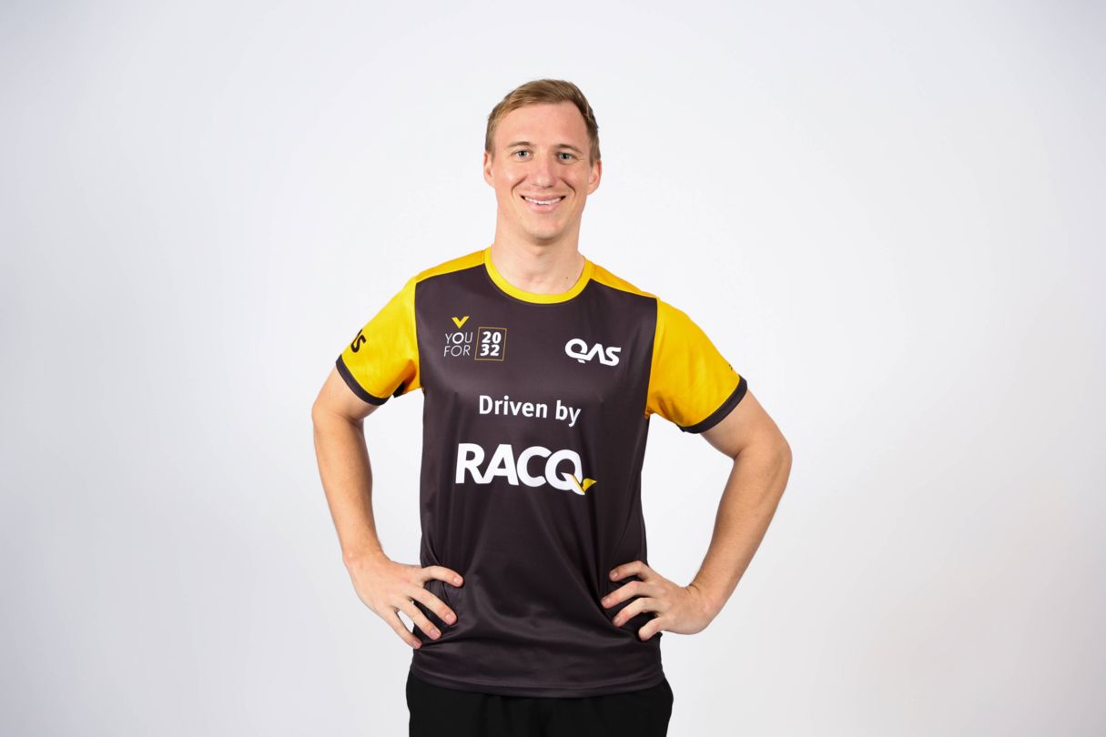 Korey Boddington, YouFor2032 Talent Search program ambassador, wears a yellow and grey YouFor2032, driven by RACQ, branded jersey in a headshot style image.