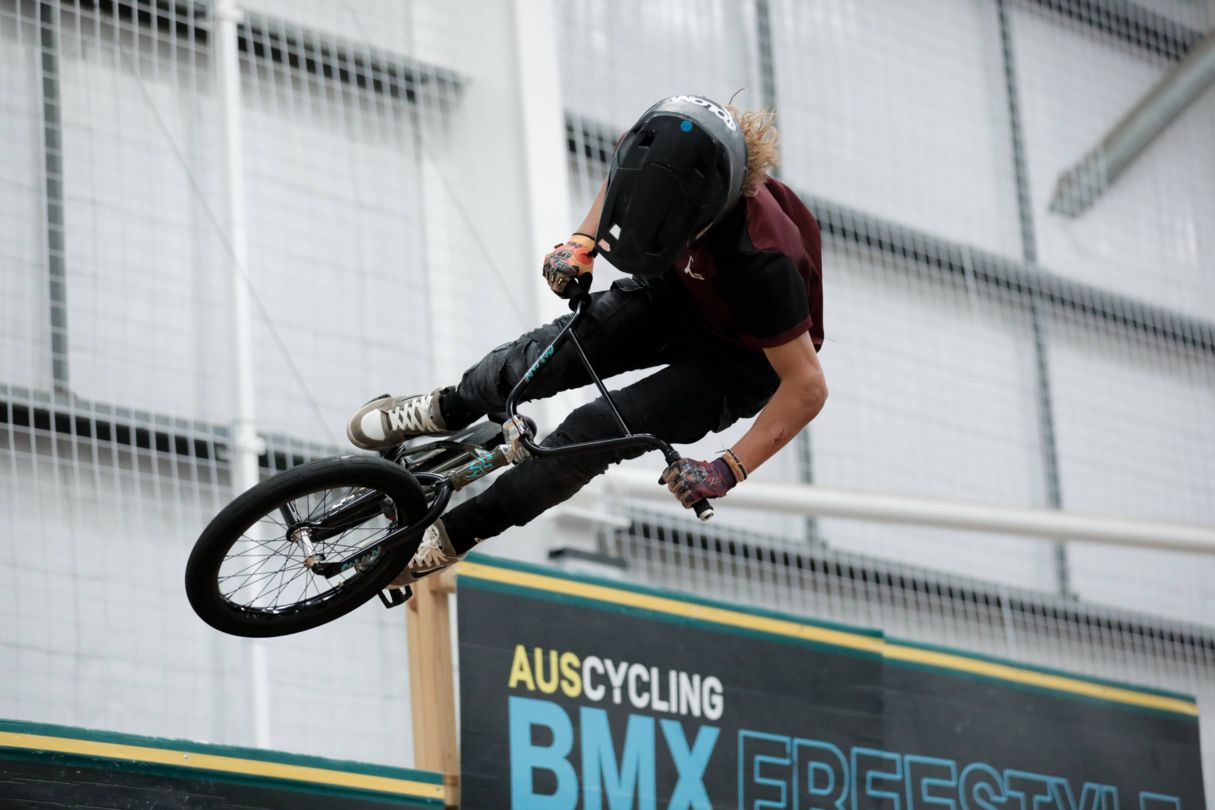 Young male athlete on BMX bike doing flip in the air