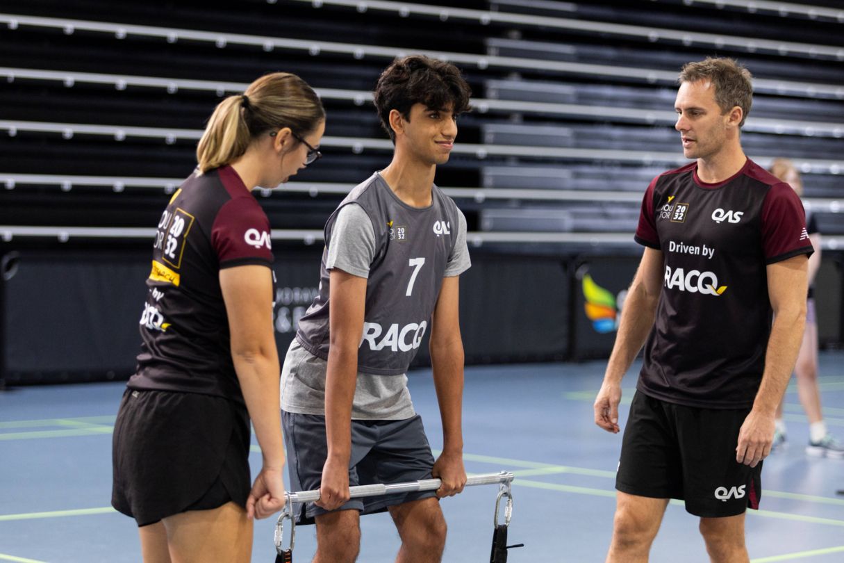 Male athlete taking part in a mid-thigh pull strength exercise with two talent team advisors watching.