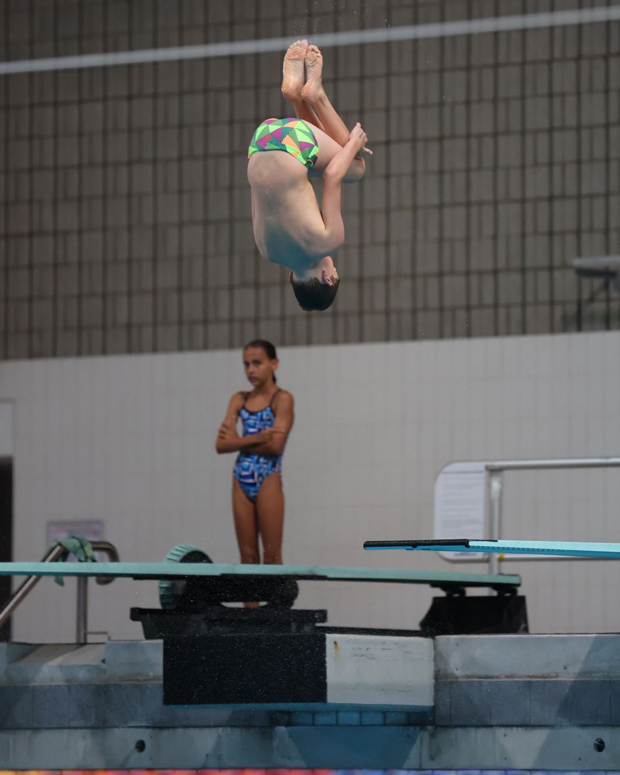 Young male athlete diving into pool.