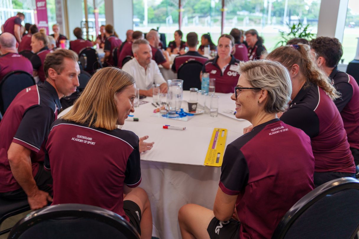 QAS staff member and athlete discussing performance, wellbeing and development goals.