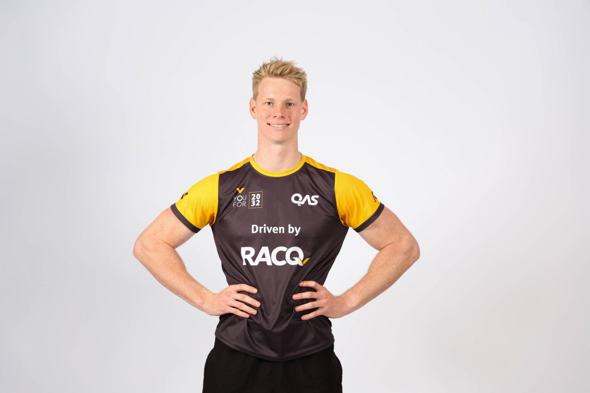 Mac Rogers, YouFor2032 Talent Search program ambassador, wears a yellow and grey YouFor2032, driven by RACQ, branded jersey in a headshot style image.