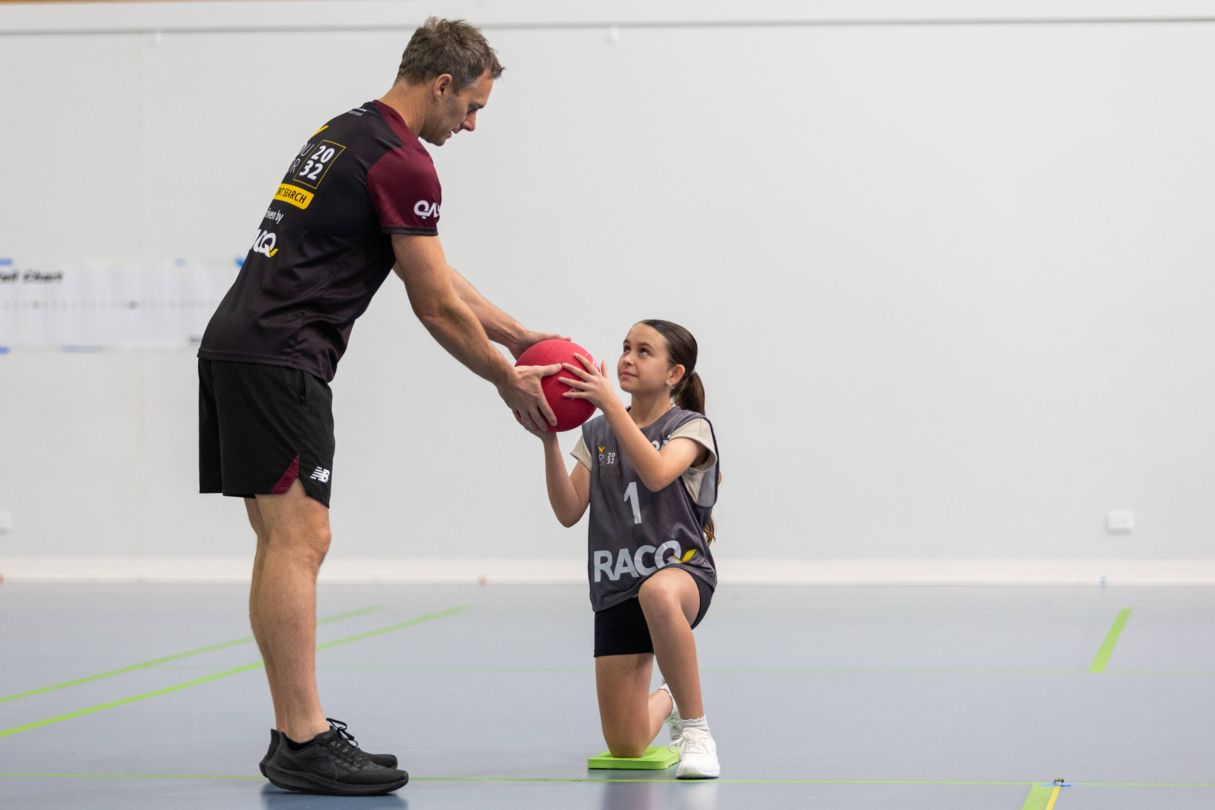 YouFor2032 Talent Advisor handing young athlete a ball
