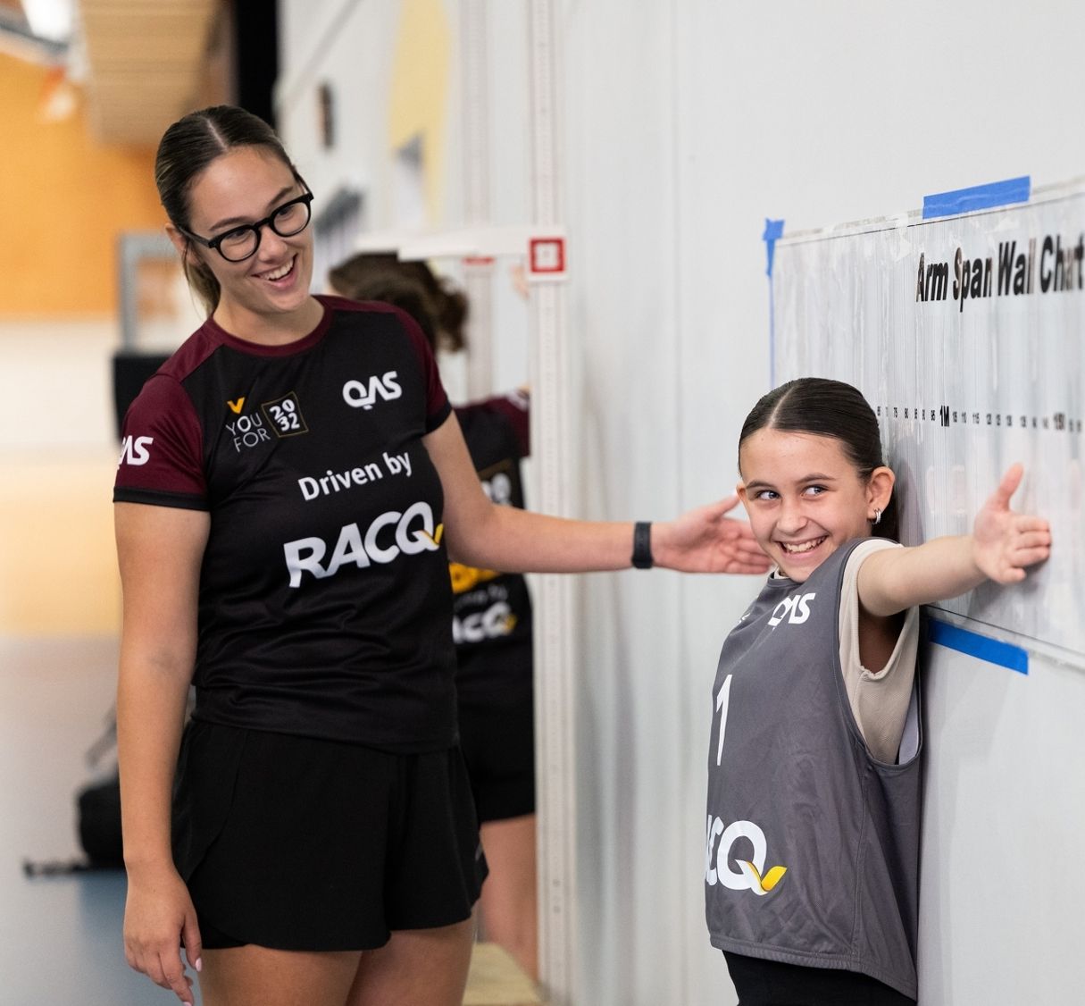 Young female athlete having her arm wingspan measured by a YouFor2032 Talent Search team member.
