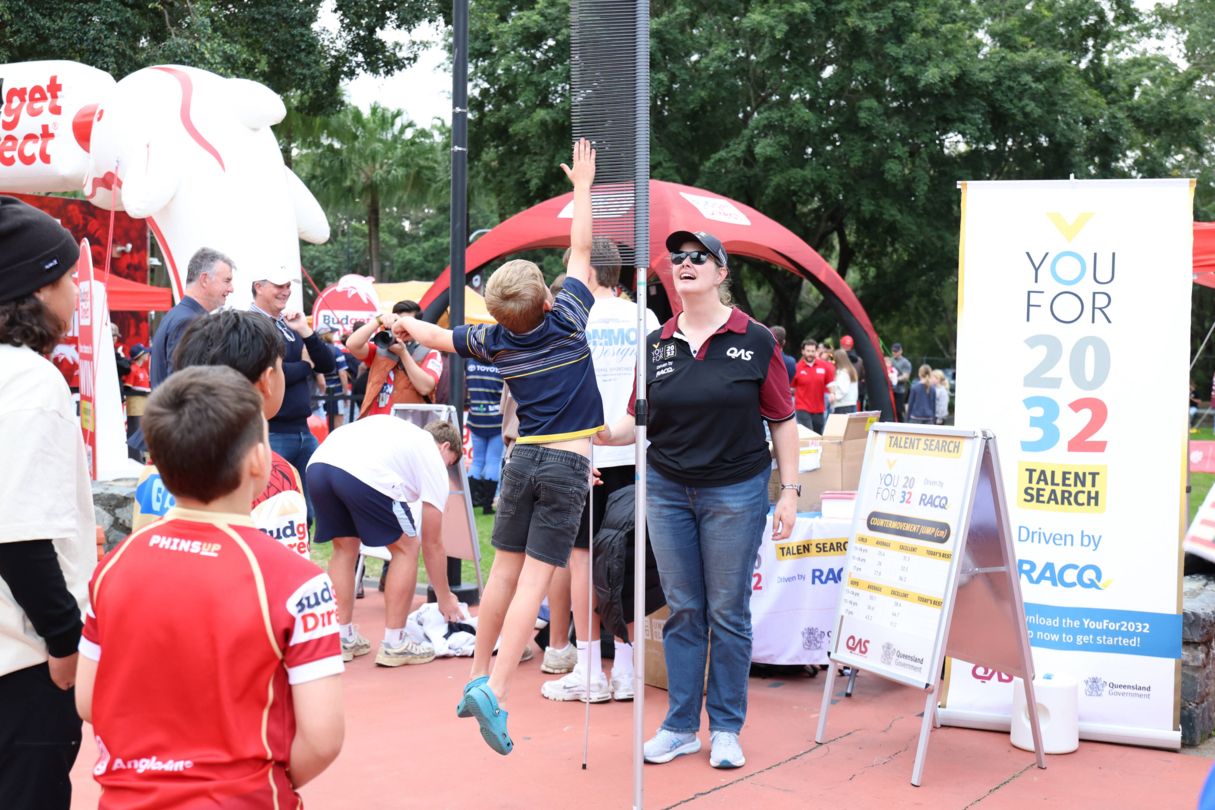 QAS Talent Advisor watches on as young boy tries to jump as high as he can.