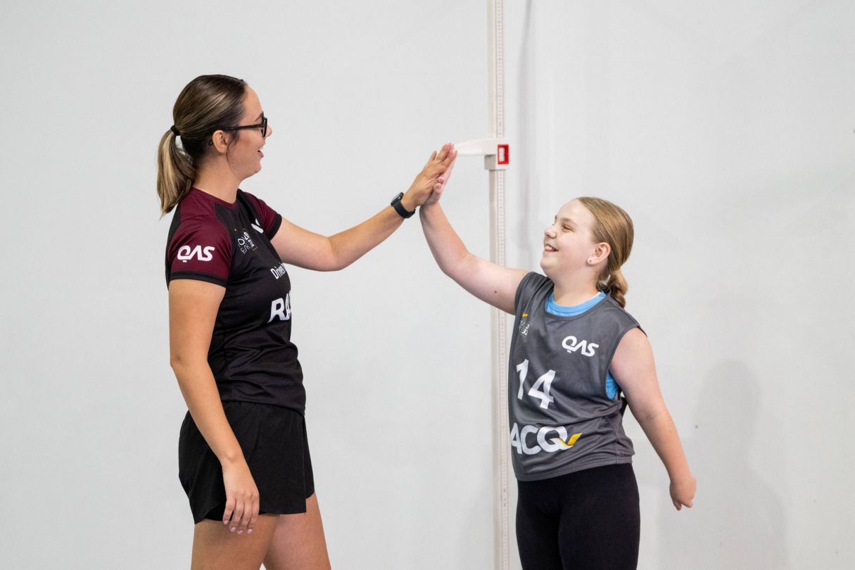 Young female athlete giving a Talent Team advisor a high five.