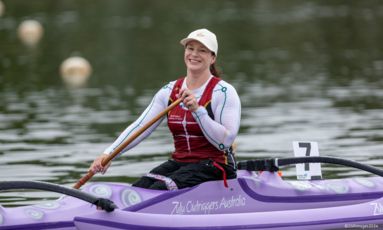 Susan Seipel is smiling at the camera while sitting in a kayak on the water