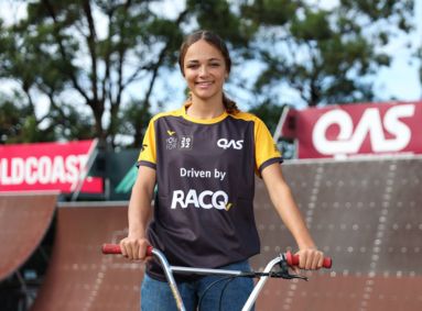 Young female BMX athlete at a skate park with her BMX bike.